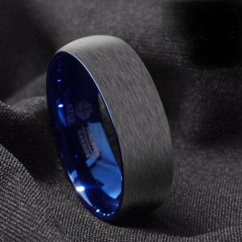 Bague pour homme noire brossée avec un intérieur bleu vif visible sur le bord de la bague