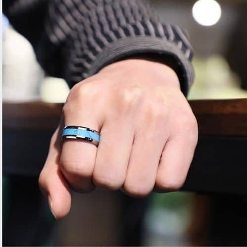 Un homme essaie sa bague en tungstène argenté et bleu