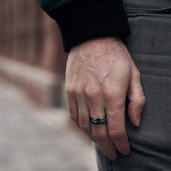 Homme portant une bague en titane noir et coquille d'ormeau