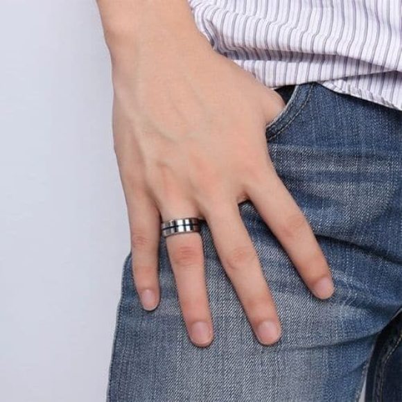 Un homme essaie sa bague en argent tungstène avec rainure bleue